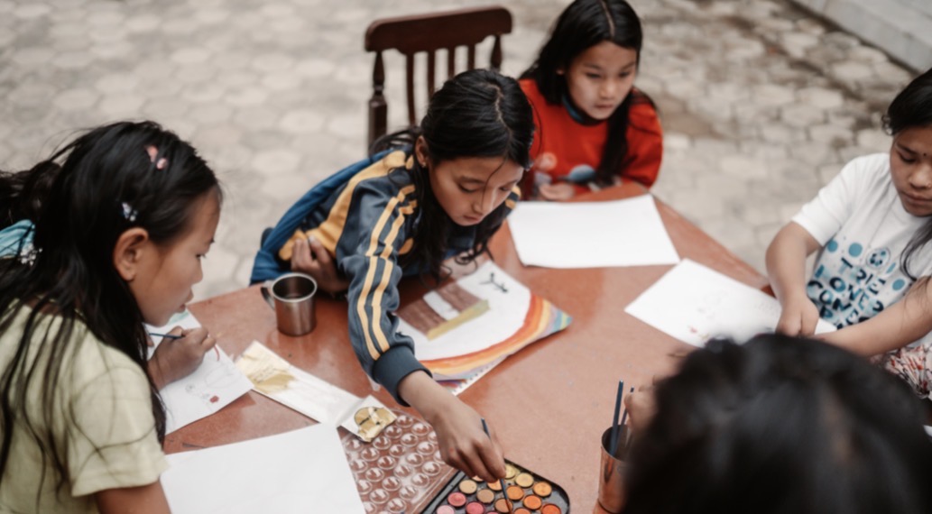 Girls painting together during an art session