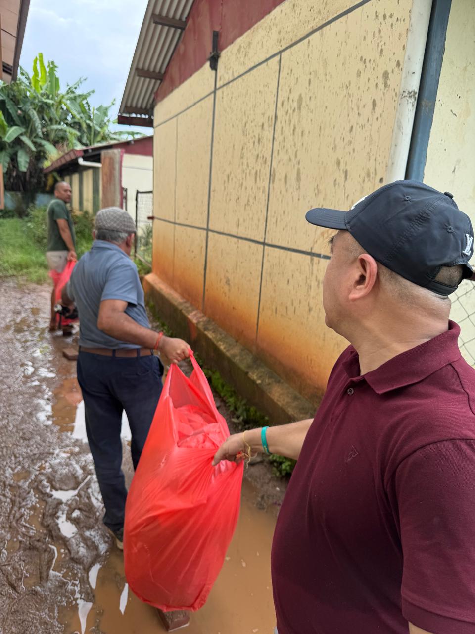 Carrying relief bags through mud and standing water.